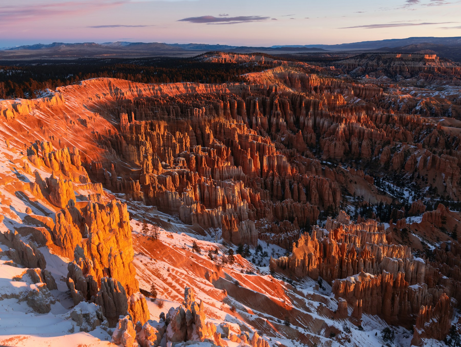 Golden sunrise illuminating the snow-covered hoodoos of Bryce Canyon National Park