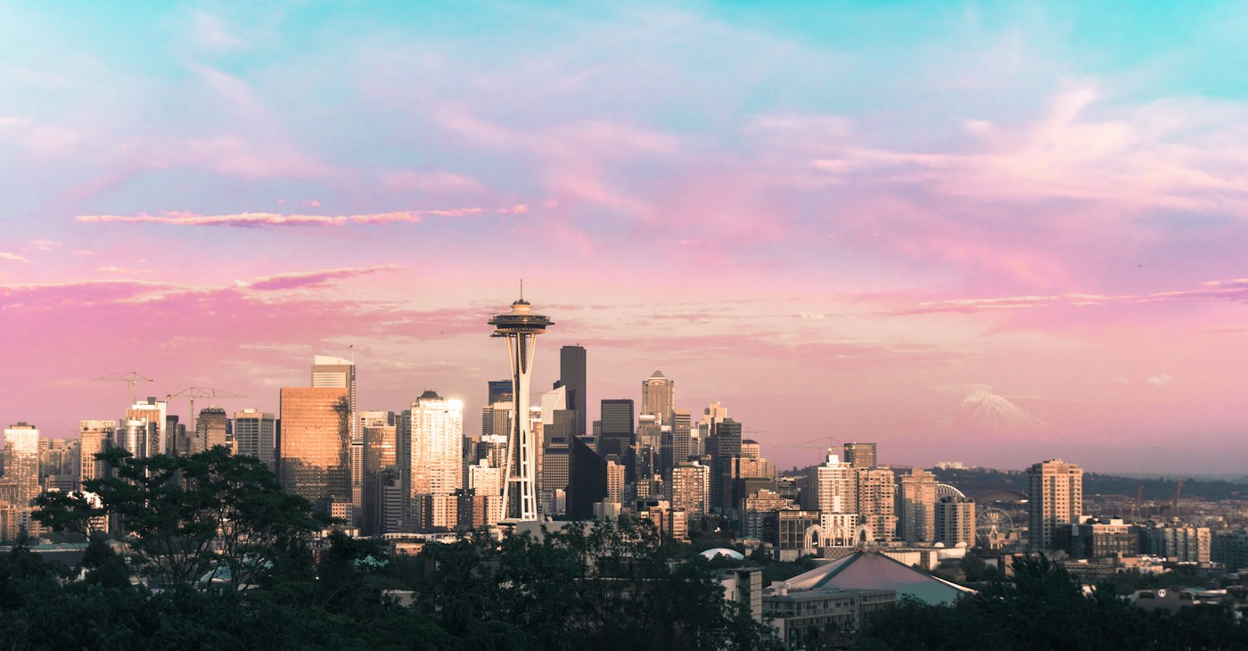 Seattle skyline and Space Needle beneath vivid pink and blue sunset clouds