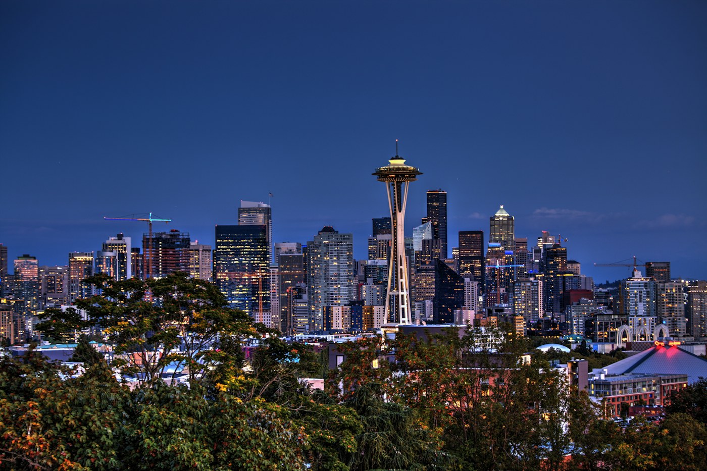 Seattle skyline and Space Needle lit against a deep blue evening sky