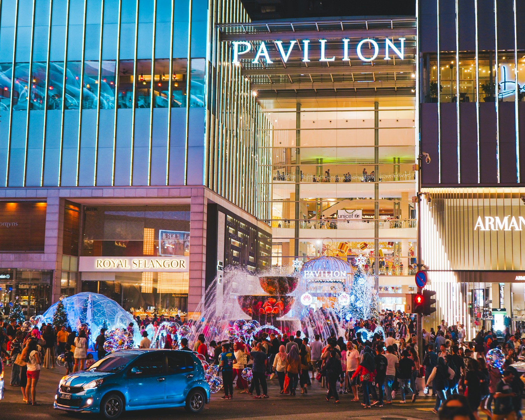 Evening crowd and illuminated entrance at Pavilion KL shopping center.