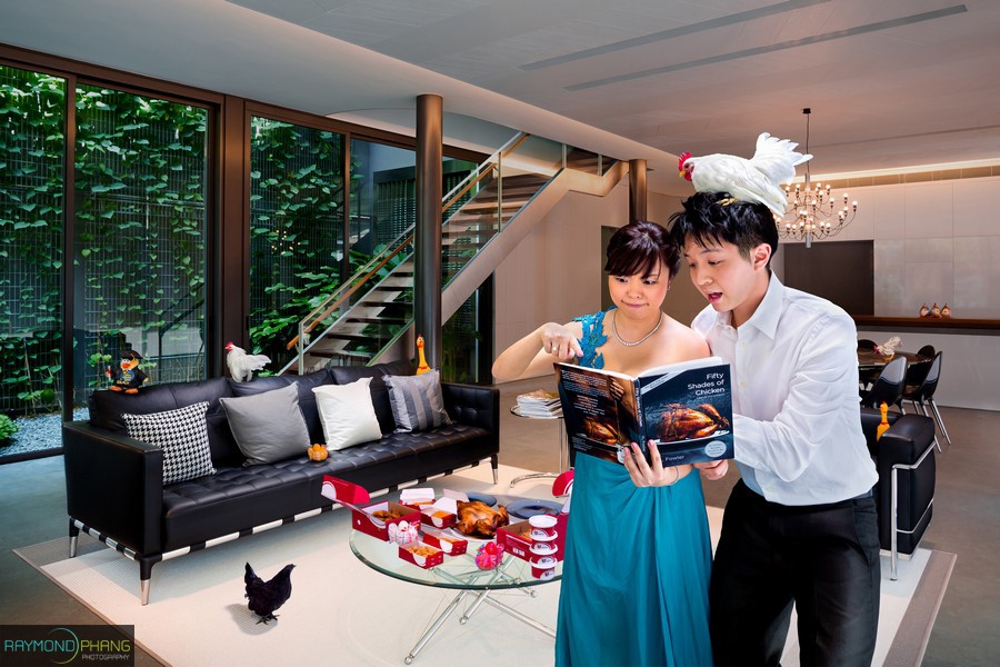 Couple in formal clothing look at a book together in a modern living room.