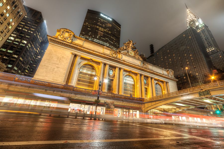 Grand Central Terminal at night with light trails along the street.