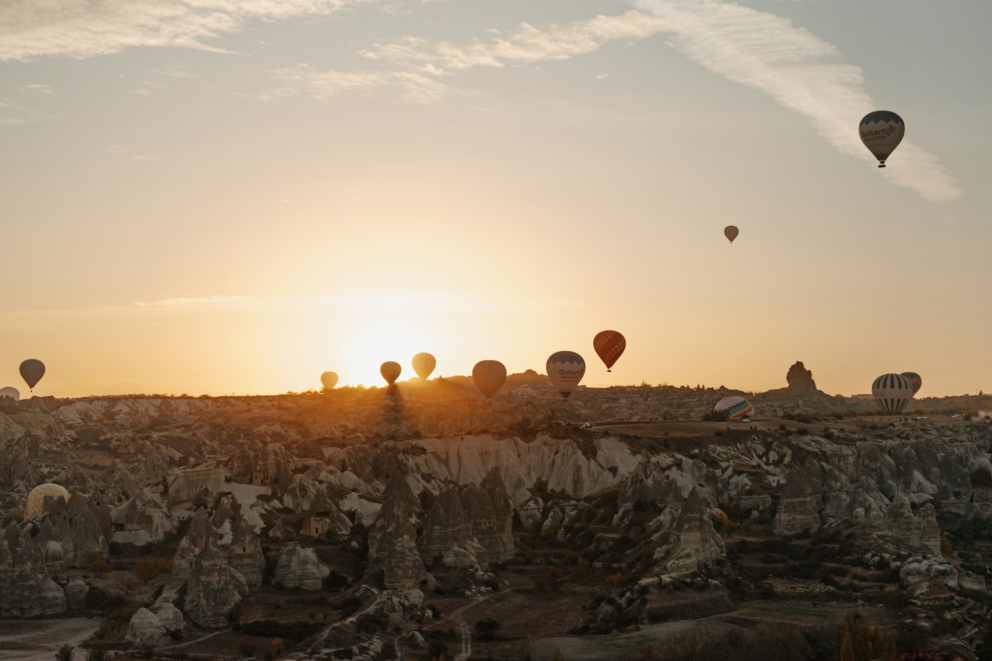 Hot air balloons rising at sunrise over the rock formations of Goreme, Cappadocia
