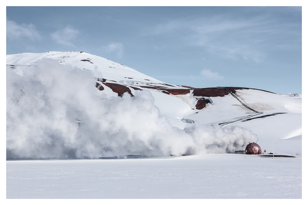 Steam rises from a snowy hillside beside a small round structure - Pause by Juan Antonio Partal