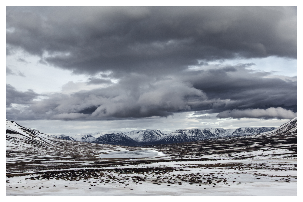 Dark storm clouds hang over a snowy mountain valley - Pause by Juan Antonio Partal