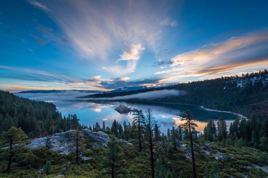 Lake Tahoe and pine-covered slopes beneath streaked blue-hour clouds