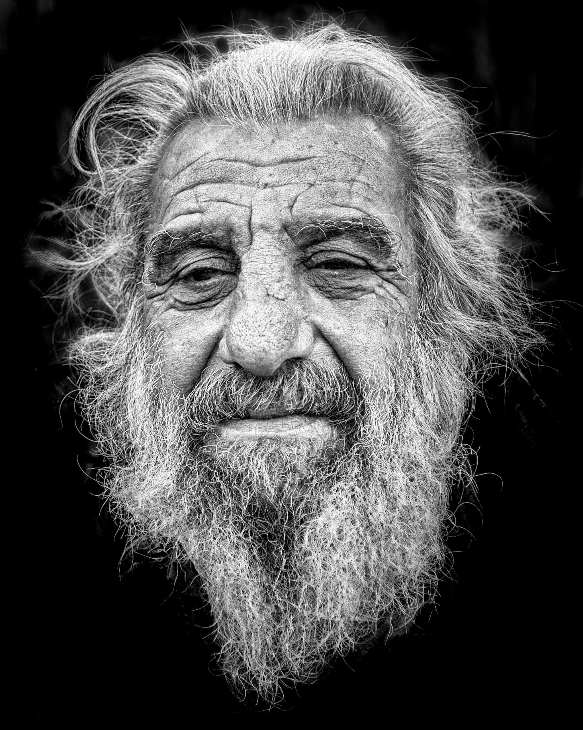 Black-and-white portrait of an older man with long white hair and beard