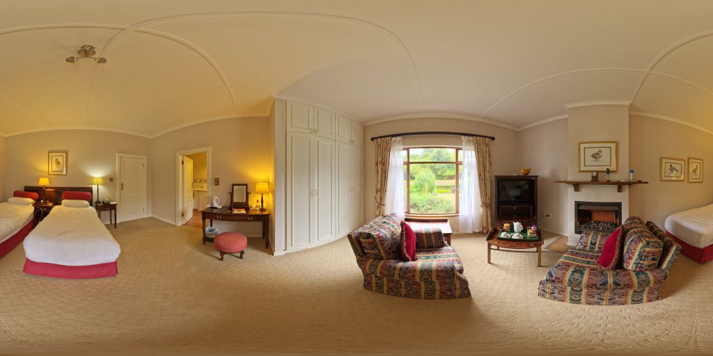 360-degree panorama of a furnished bedroom and living area with a fireplace and windows