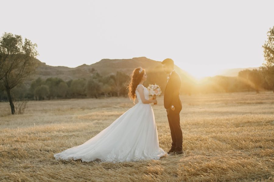 Bride and groom embracing in a sunlit meadow