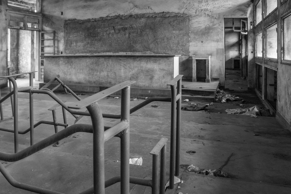 Empty, damaged interior with an open doorway and scattered debris.