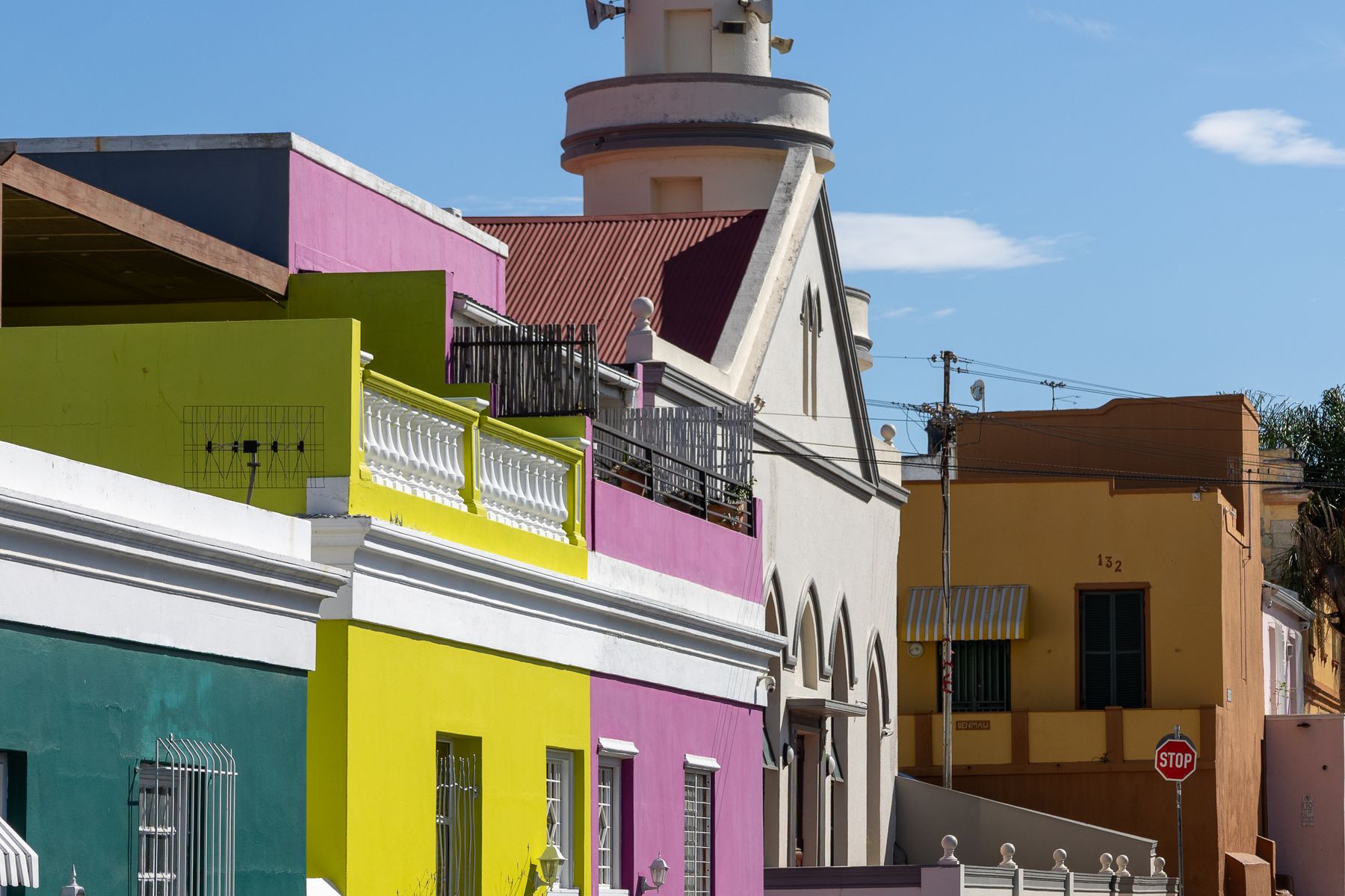 Brightly painted houses in the Bo-Kaap neighborhood of Cape Town under a blue sky