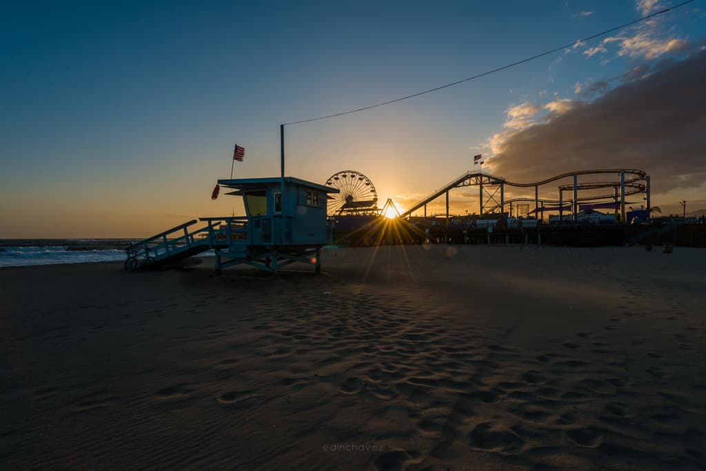 Santa Monica Pier and lifeguard tower silhouetted against a golden sunset
