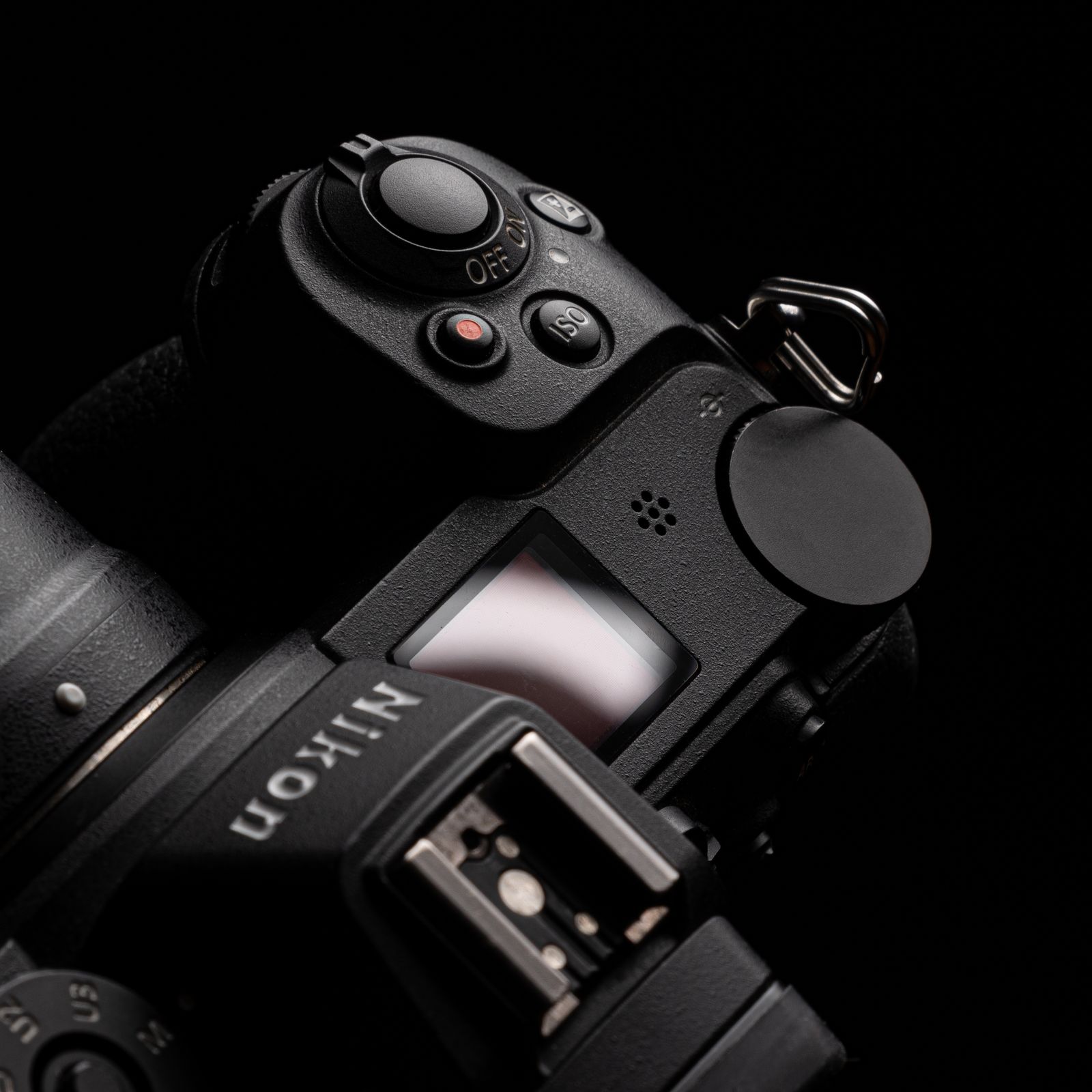 Black DSLR camera with a lens on a flat surface