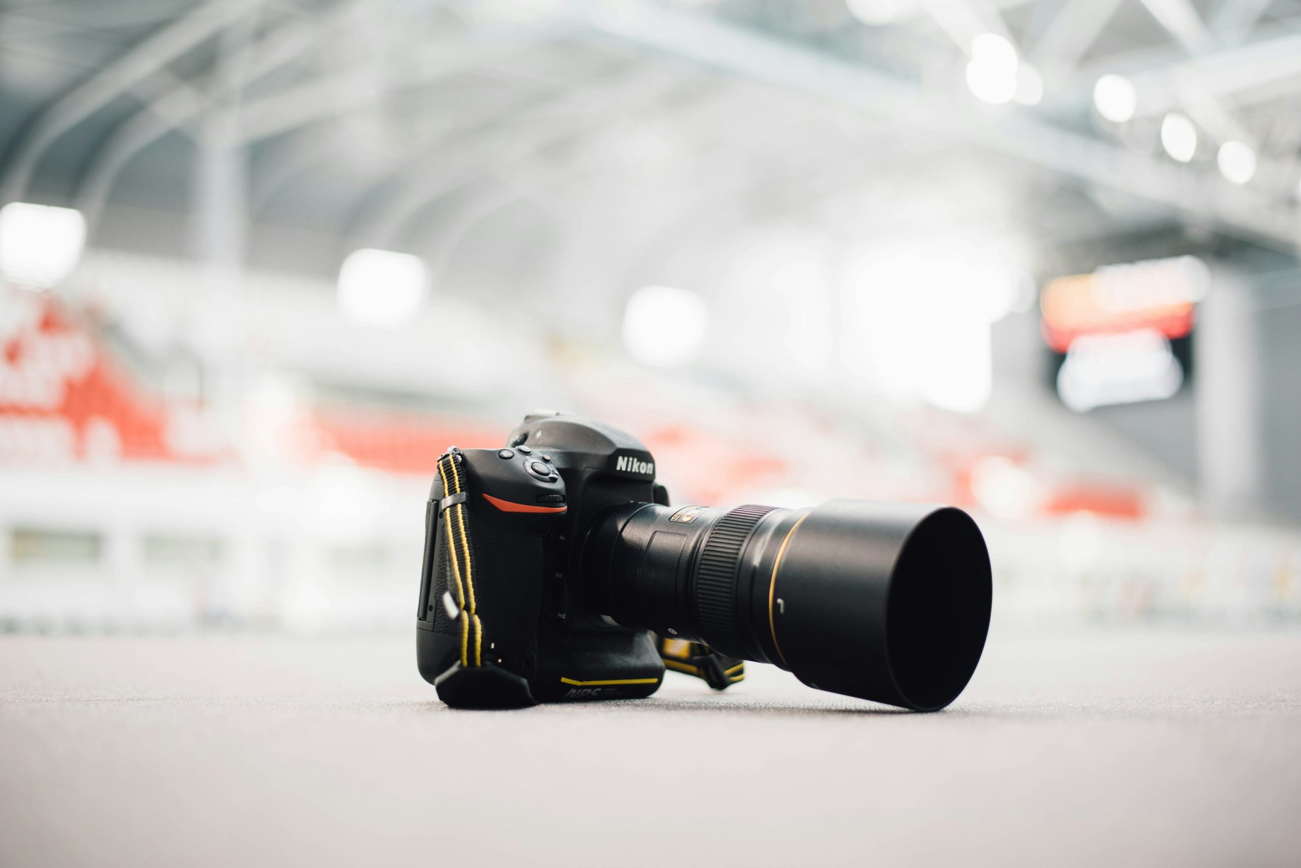 A Nikon DSLR with a zoom lens resting on a light-colored surface.