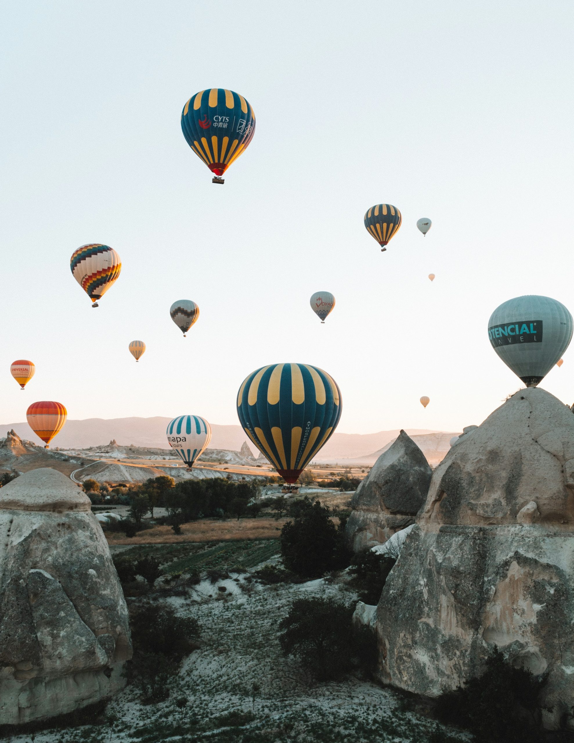 Hot air balloons above Cappadocia rock formations in morning light