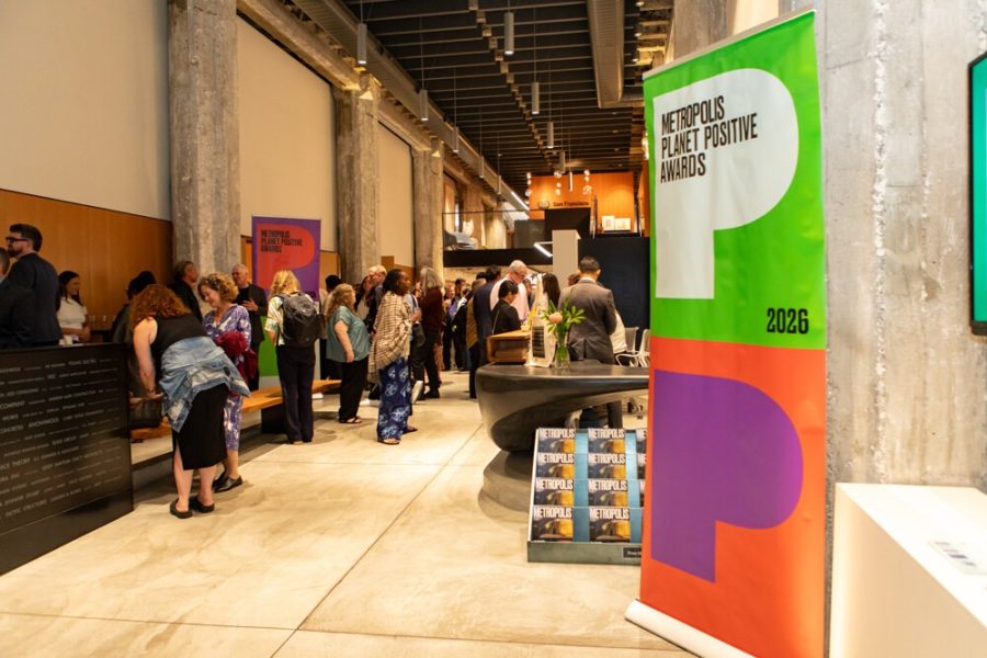 Conference attendees in a bright event lobby beside colorful branding