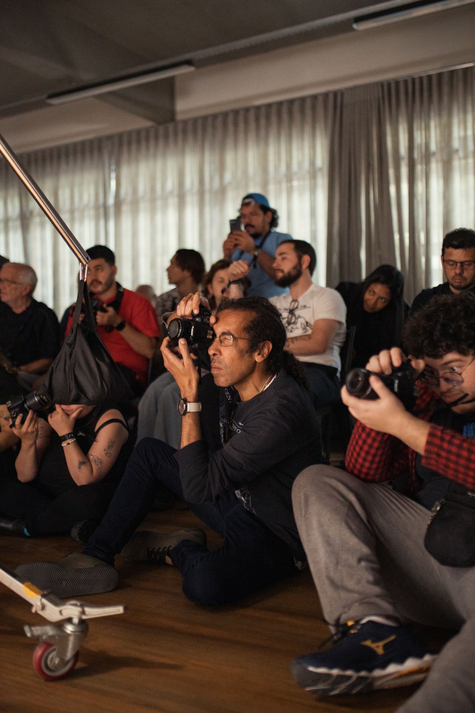 Photographers crouched in the audience shooting a corporate conference session