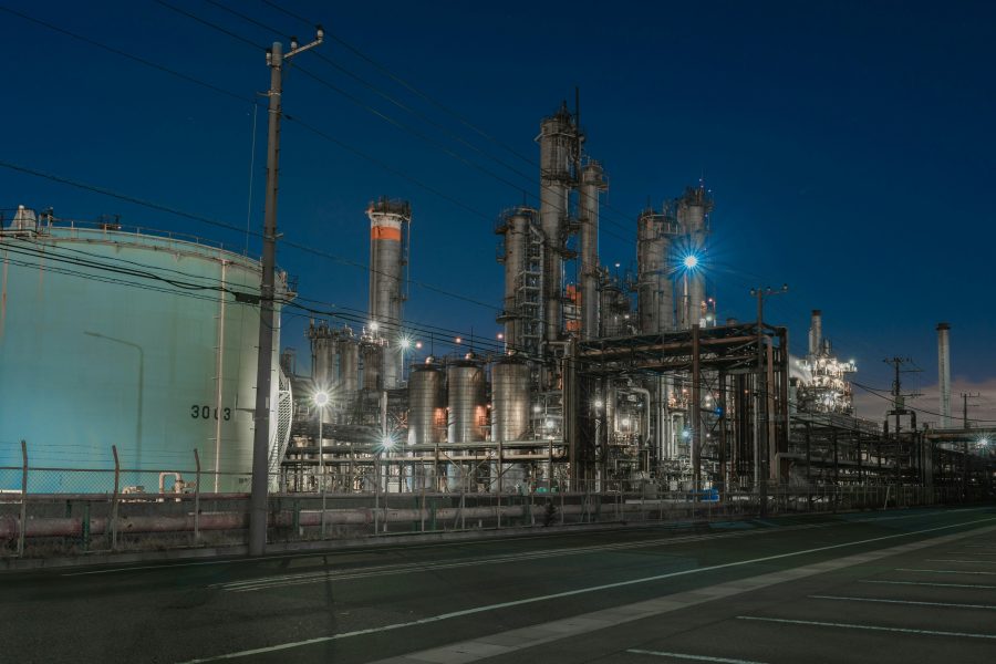 Industrial exterior in Kawasaki, Japan, with illuminated towers, pipework and a large cylindrical enclosure at night