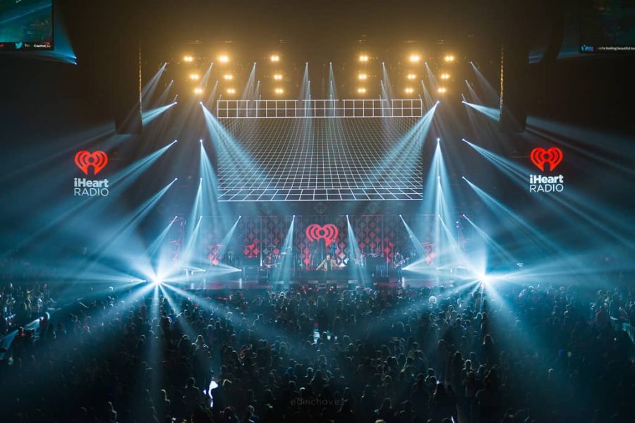 Concert stage with blue and golden lights above a packed live-event audience