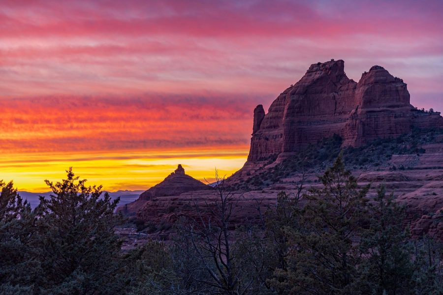 Sunset over Mitten Ridge in Sedona, Arizona, with orange and magenta clouds above red sandstone buttes