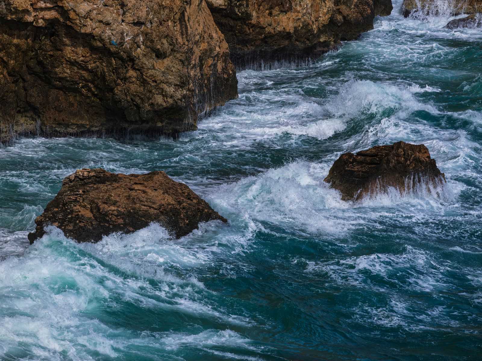 Ocean waves crashing against rocky cliffs