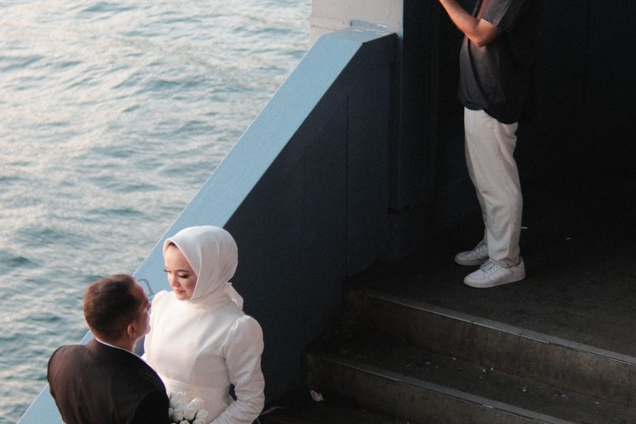 Wedding photographer making a portrait of newlyweds beside the water