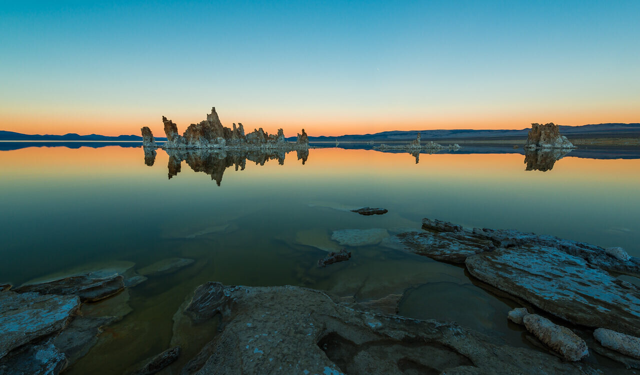 Mono Lake tufa reflected in calm water at sunset, photographed by Edin Chavez
