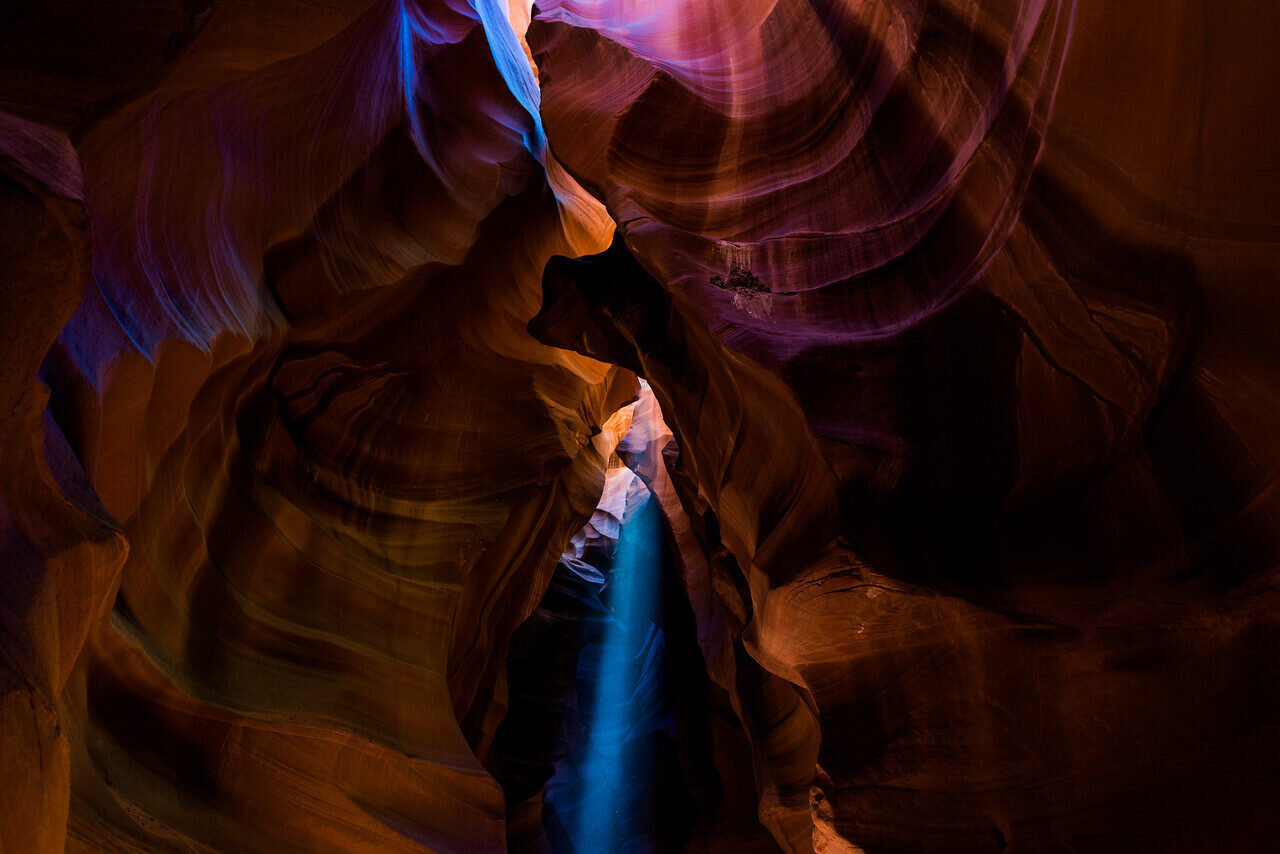 Orange sandstone walls and a beam of light inside Antelope Canyon, Arizona, photographed by Edin Chavez