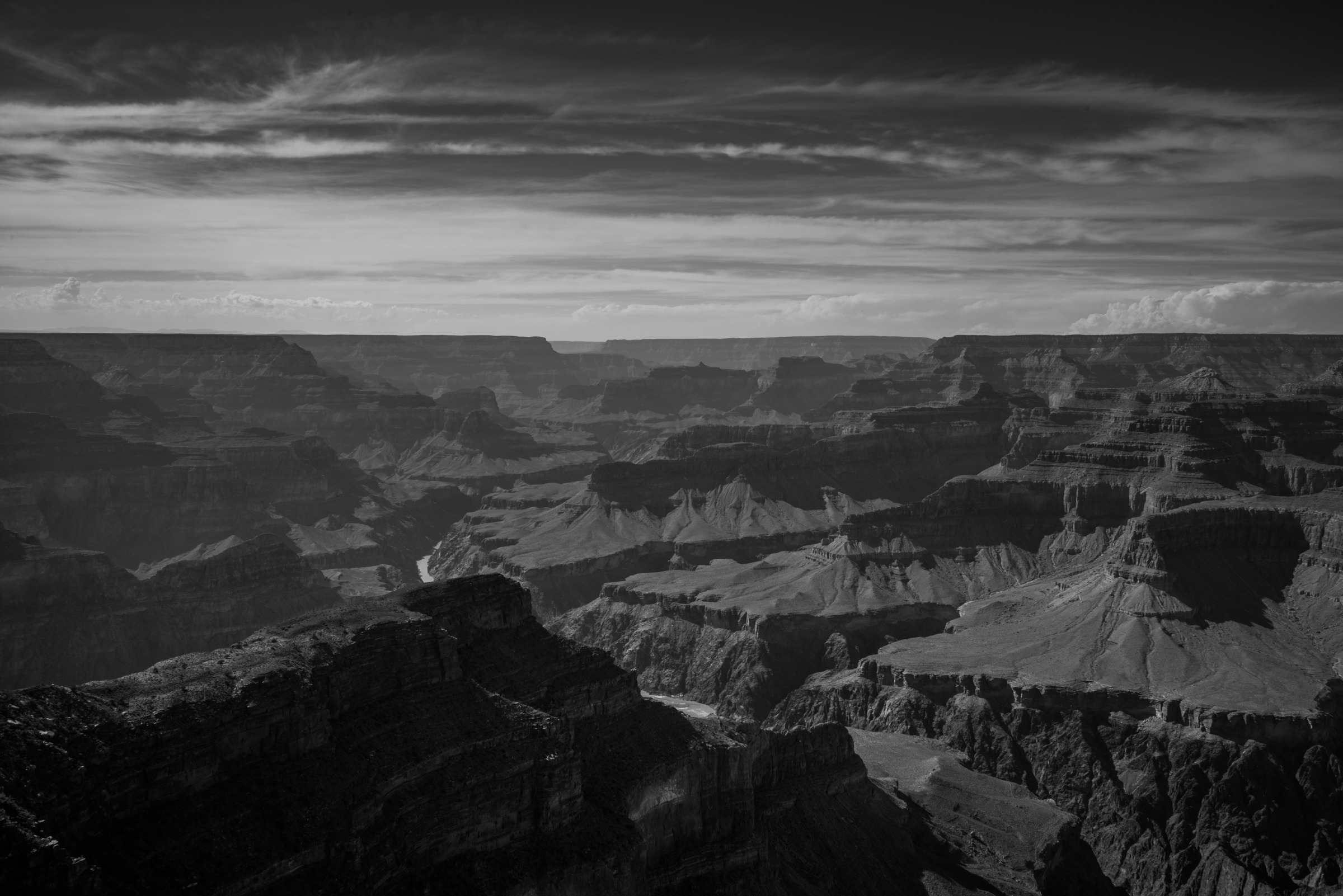 Edin Chavez black and white Grand Canyon photograph with layered cliffs and a textured sky