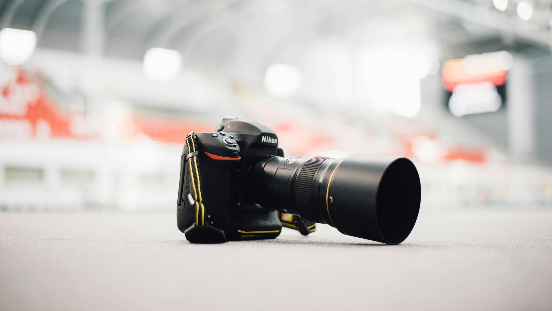 A Nikon DSLR with a zoom lens resting on a light-colored surface.
