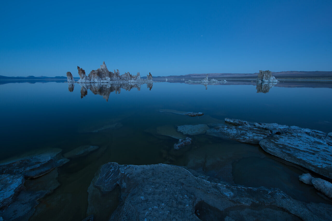 Mono Lake tufa towers reflected in still water at blue hour, photographed by Edin Chavez