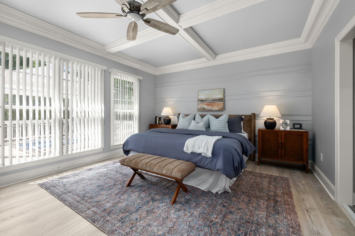 Bedroom with natural light, layered bedding and a bench at the foot of the bed