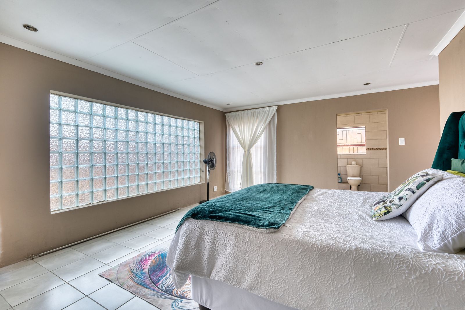 Spacious bedroom with natural light, a before and after editing subject