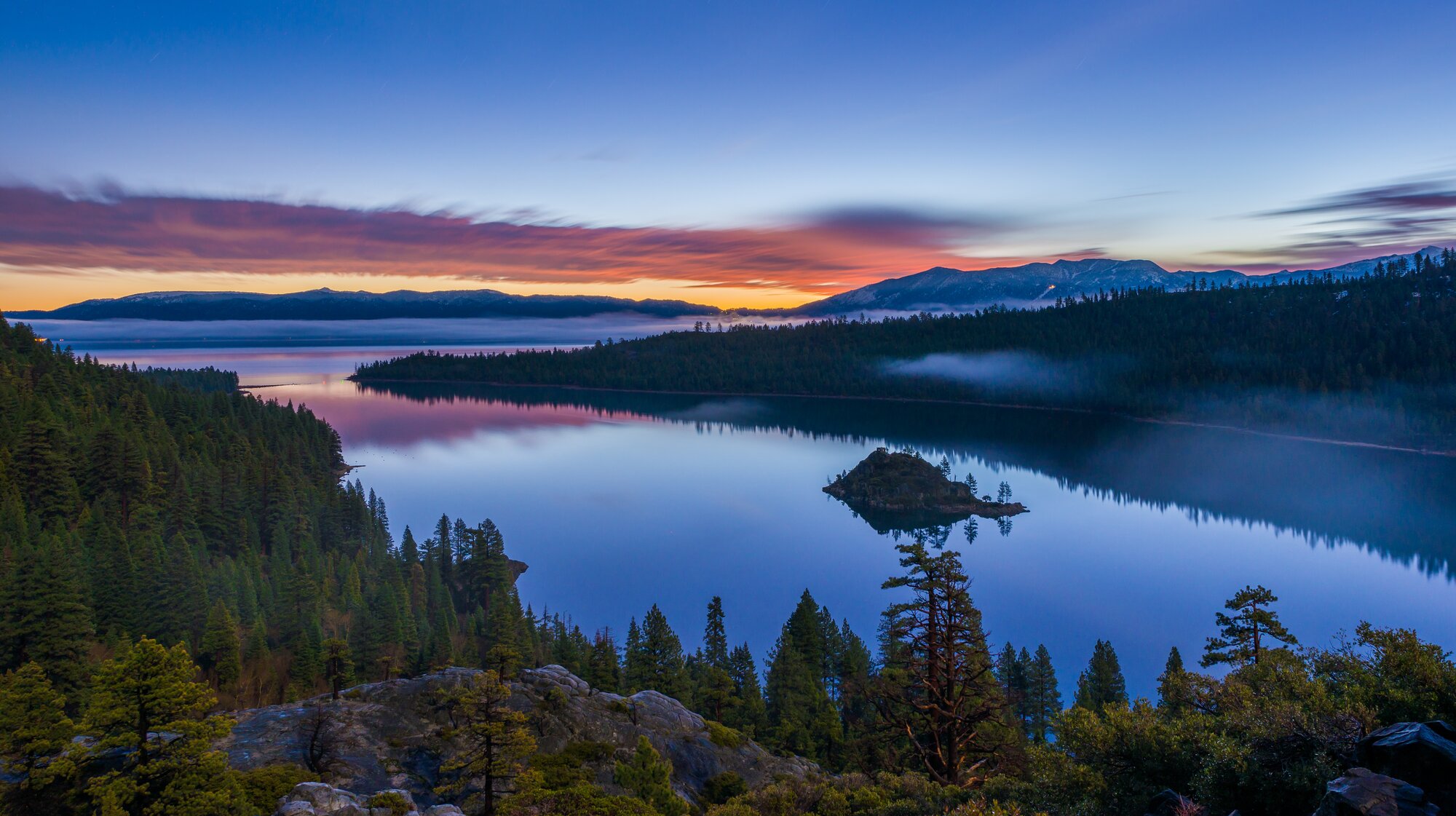 Landscape photo of Emerald Bay at Lake Tahoe at blue hour with pink clouds over still water