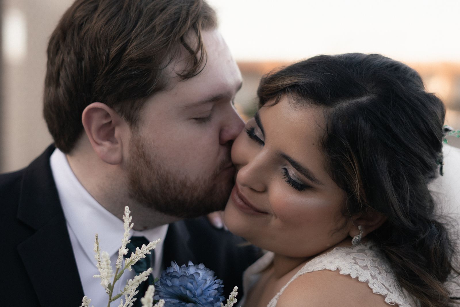 How to Choose a Wedding Photographer - groom kissing bride on the cheek in golden hour light