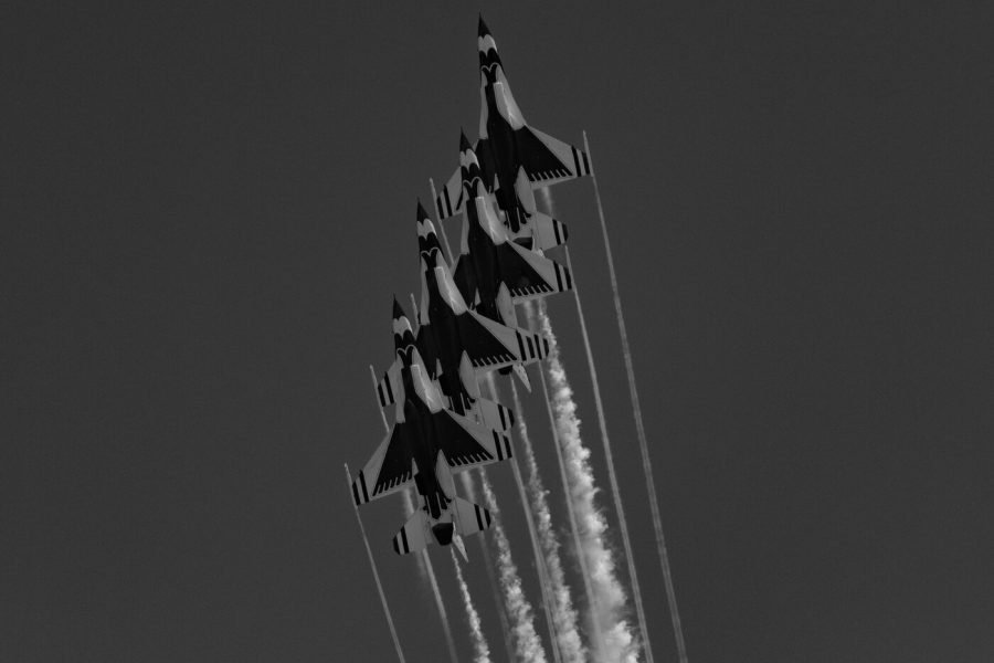 Black and white photo of a stack of USAF Thunderbirds F-16 jets climbing steeply with parallel smoke trails