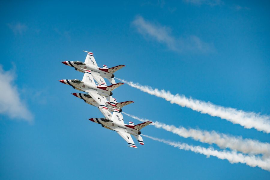 Four Thunderbirds jets banking in close formation at an air show