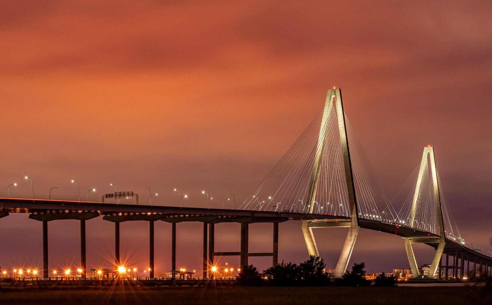 Arthur Ravenel Jr. Bridge lit at dusk under a glowing orange sky, Charleston, South Carolina