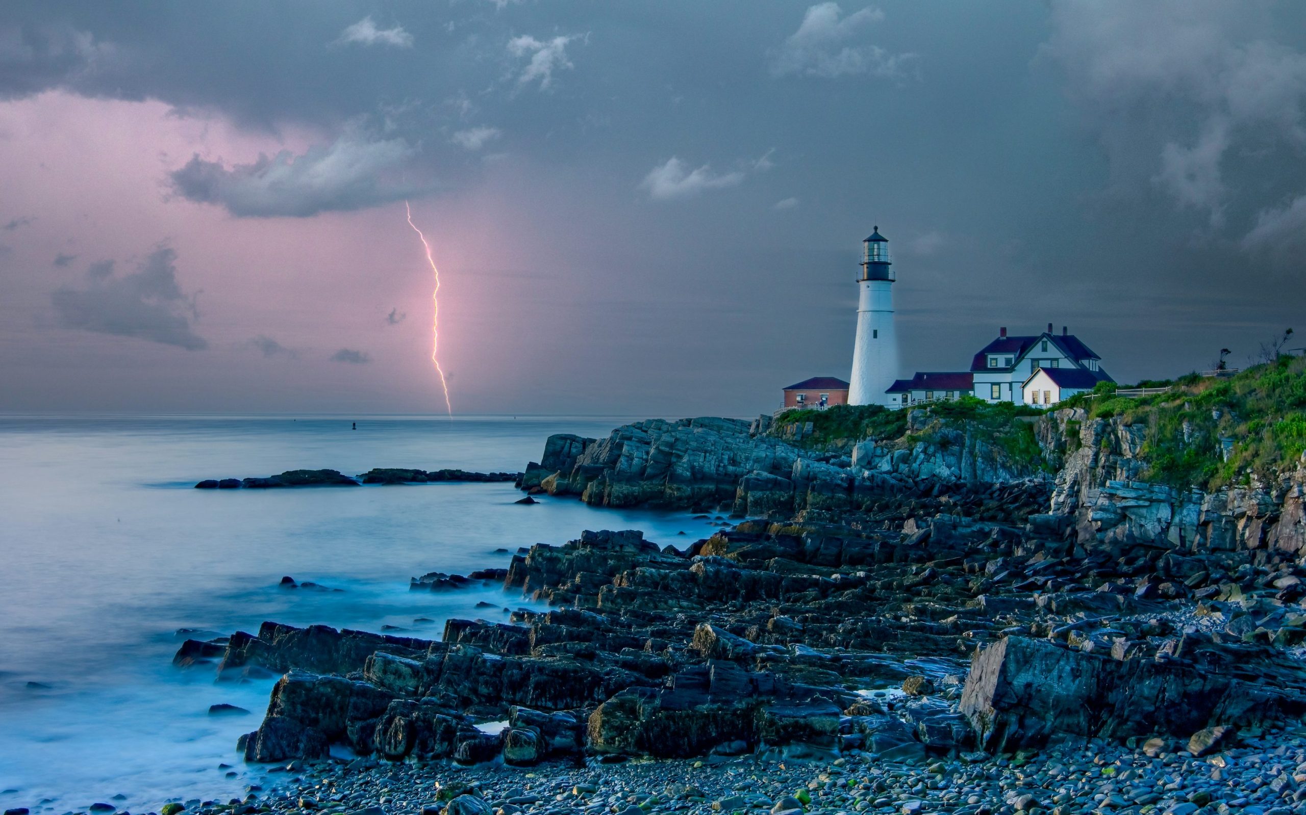 Lightning over the ocean beside Portland Head Light and rocky coast in Cape Elizabeth, Maine