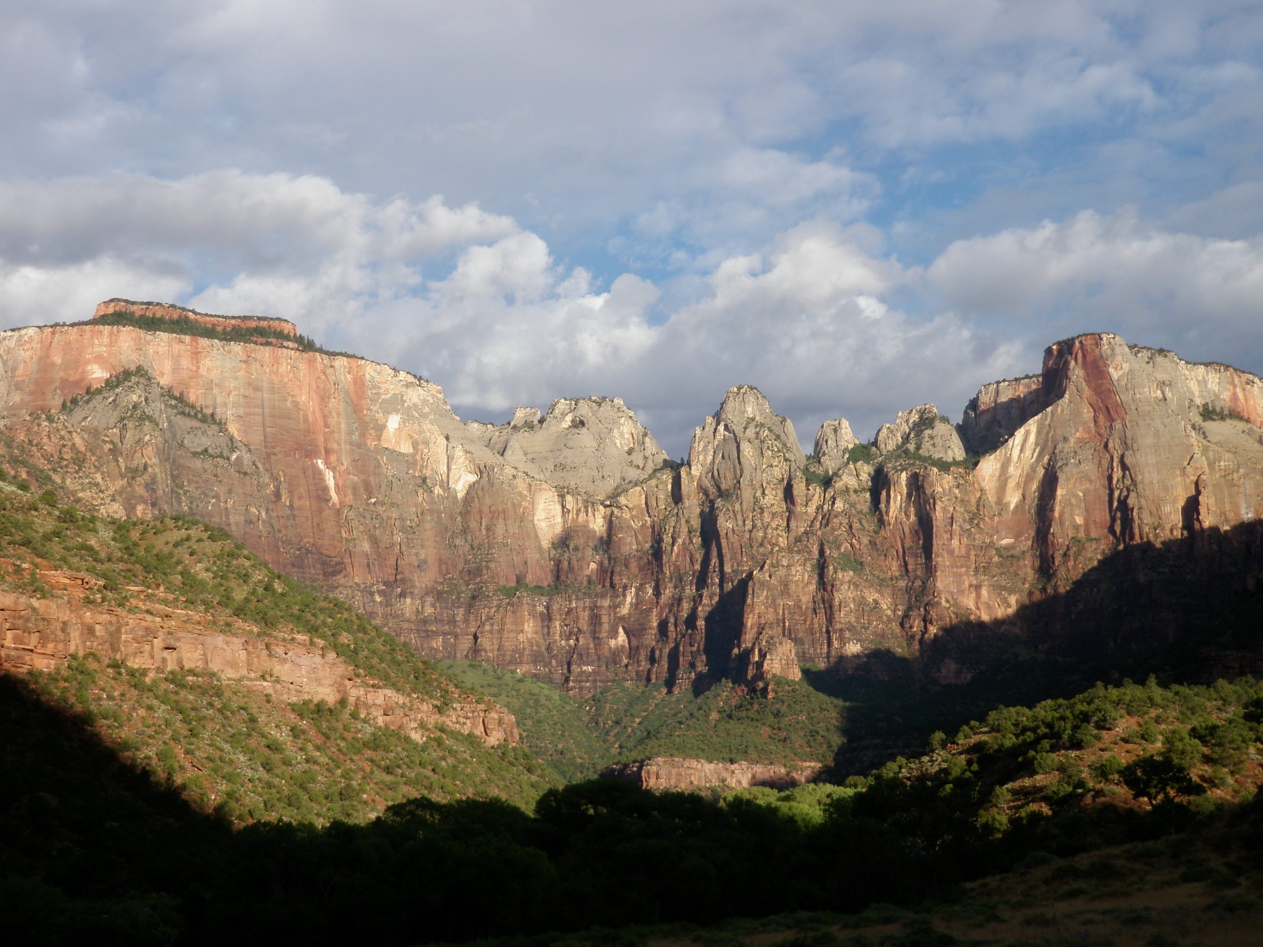 Warm sunrise light on the Temples and Towers of the Virgin above a shadowed canyon floor, NPS photo by Rebecca Alfafara