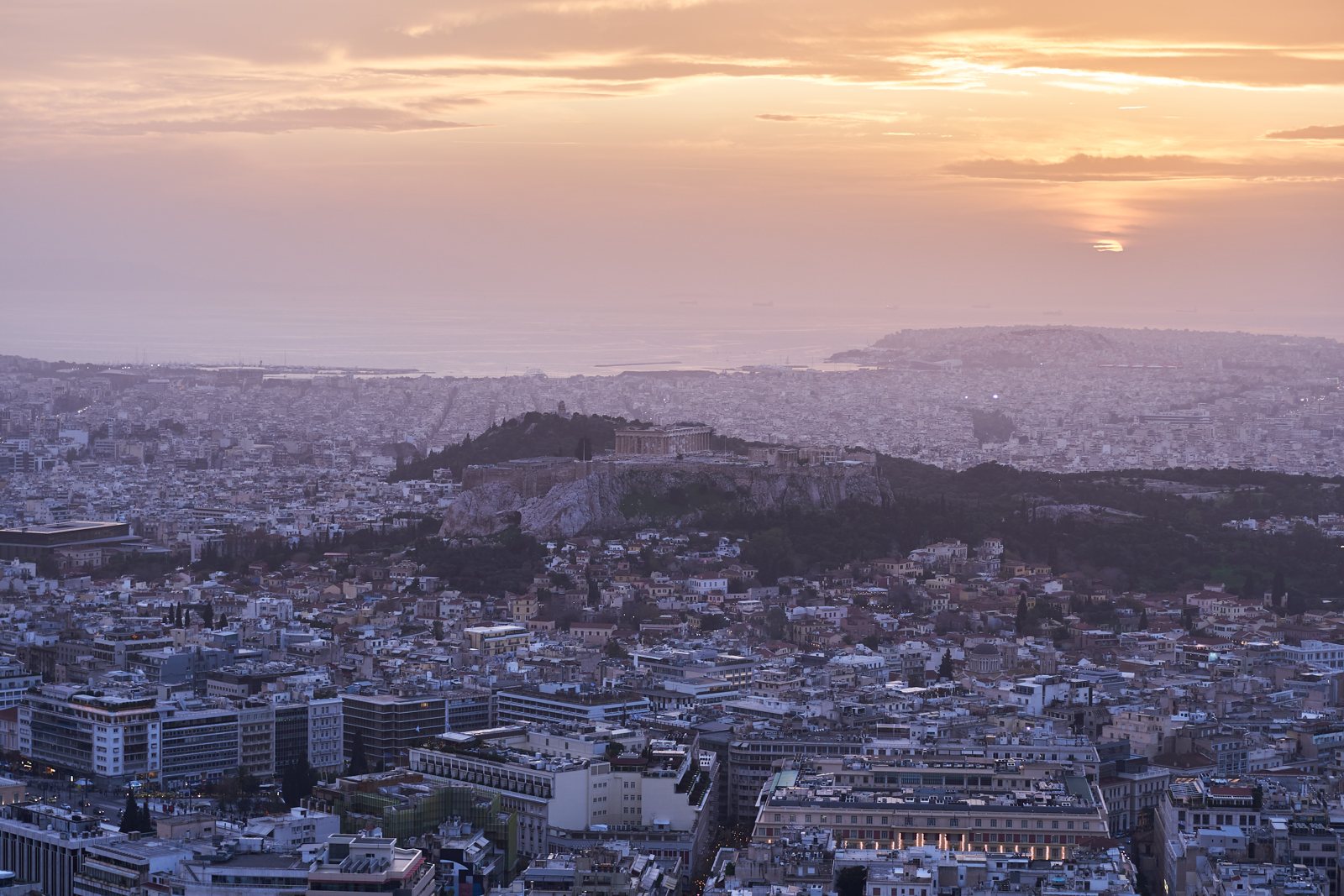 The Acropolis at sunset seen from Mount Lycabettus with the city and the sea beyond