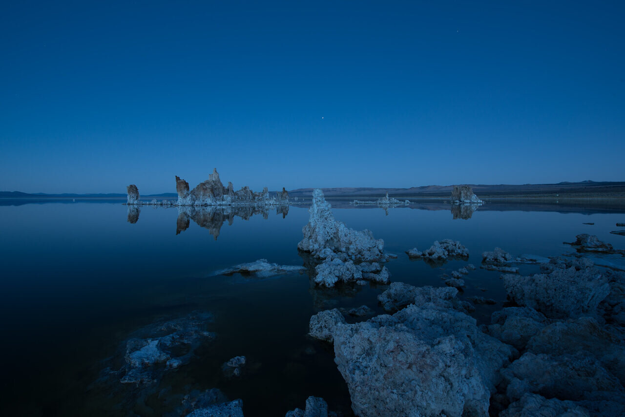 Mono Lake tufa towers reflected in still water at blue hour, photographed by Edin Chavez