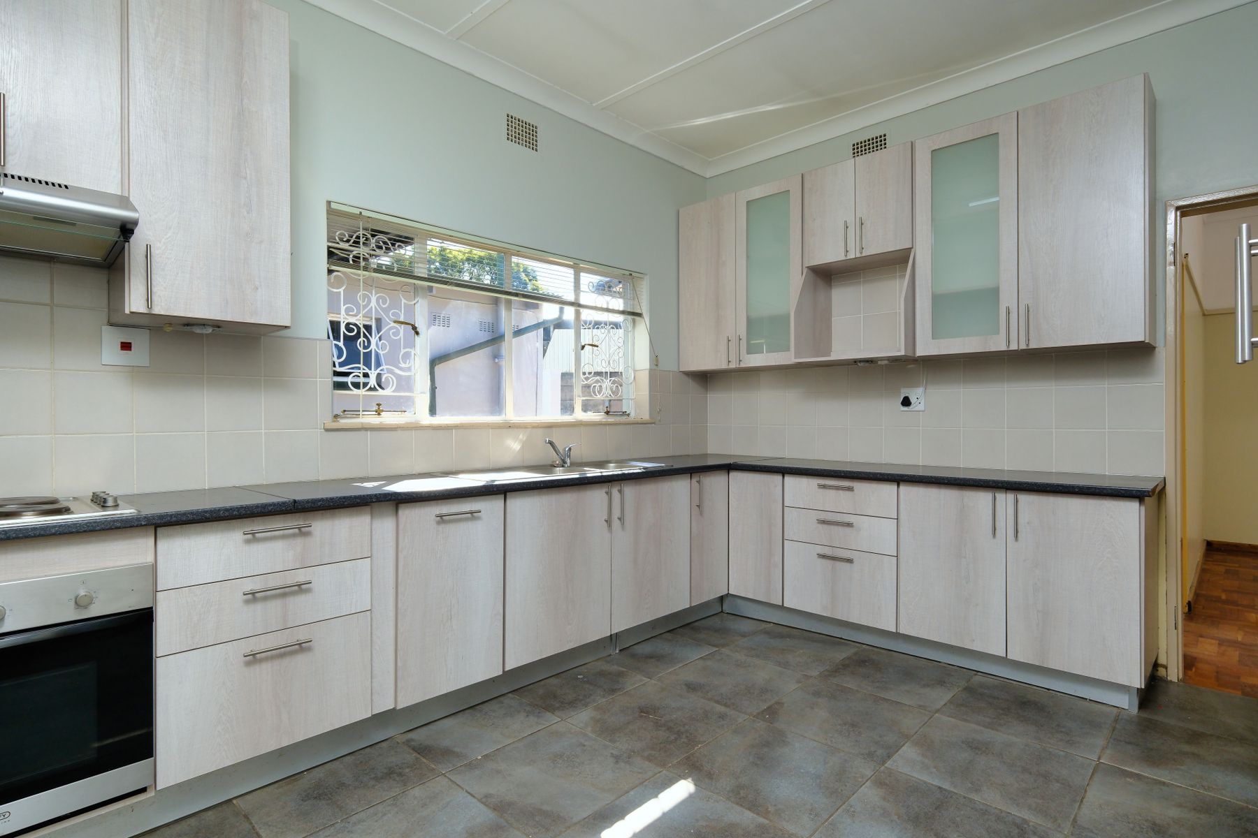 Bright kitchen with a window above the counter and clean surfaces.