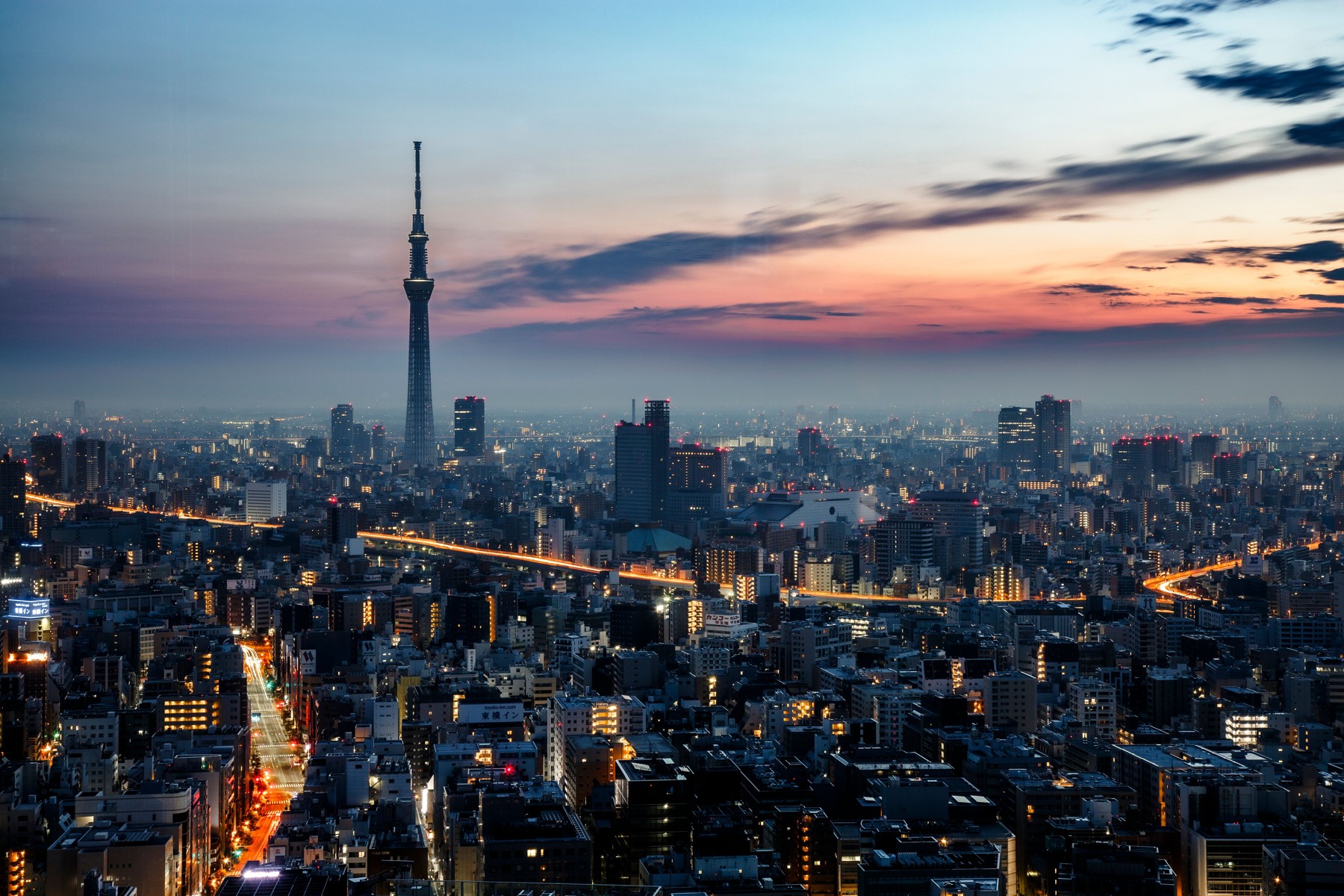 Tokyo Skytree above a dense city skyline under a pink and blue dusk sky