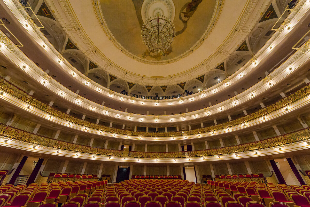 Ornate multi-tier theater interior with red seats in Cuba, photographed by Edin Chavez
