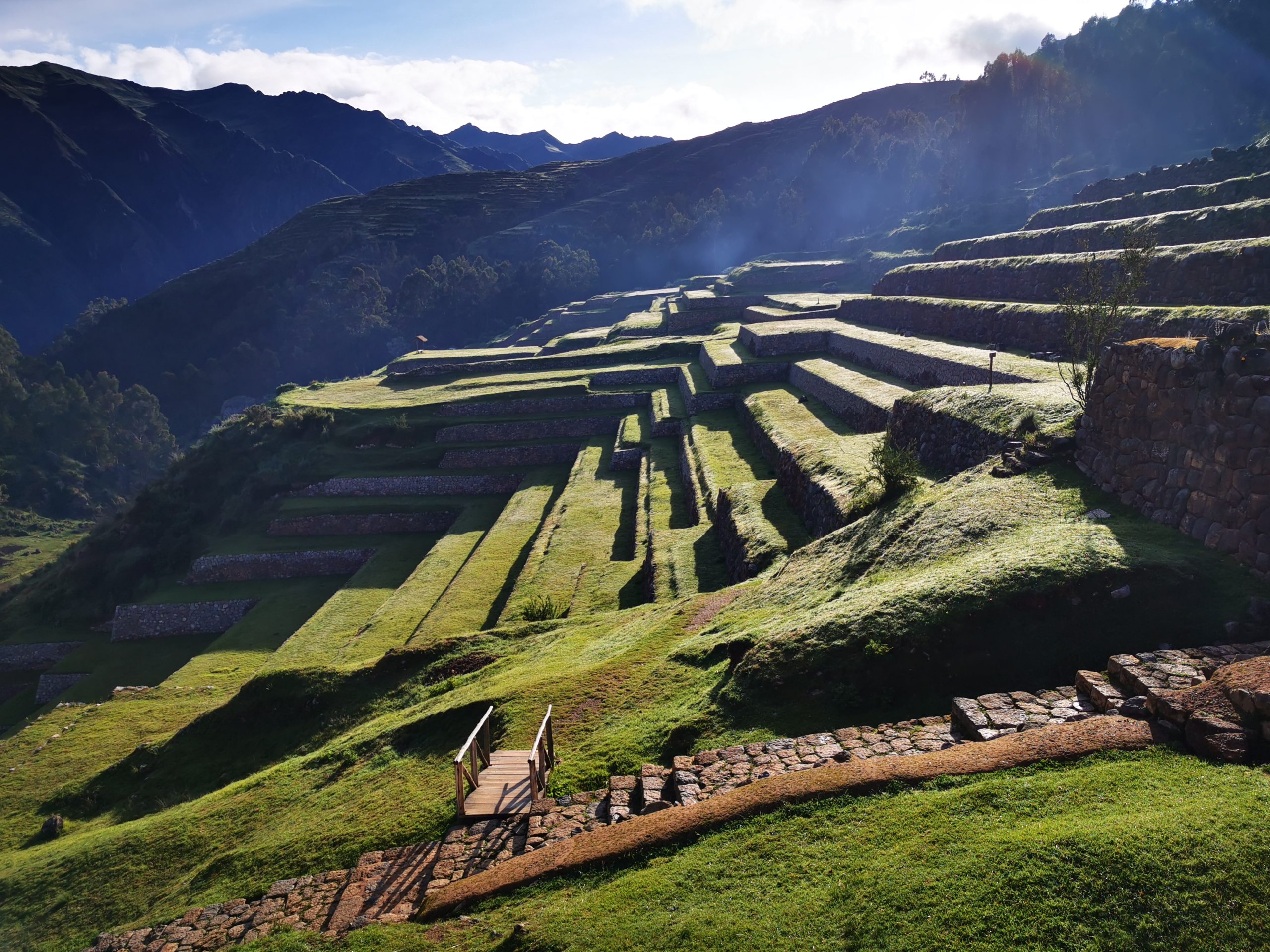 Side light separating grass terraces and Inca stonework at Chinchero.