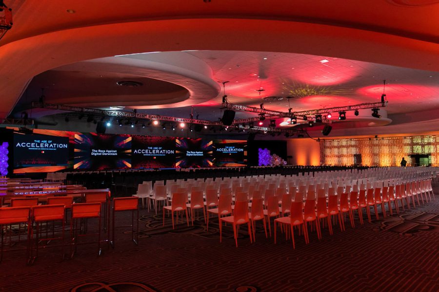Conference venue with dramatic red lighting and rows of seats