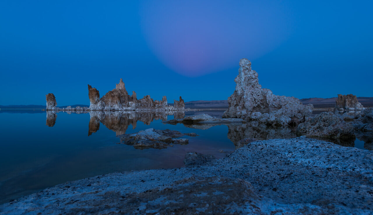 Mono Lake tufa towers under a rising moon at blue hour, photographed by Edin Chavez