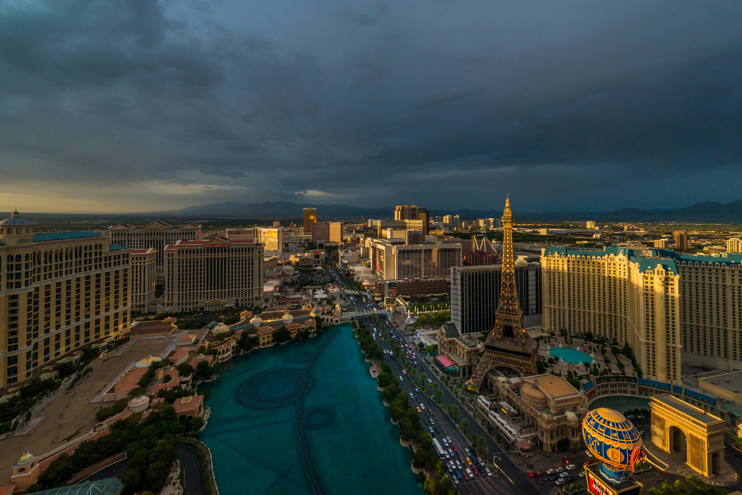 The Las Vegas Strip at blue hour from above, with the Bellagio fountains and resort lights coming on