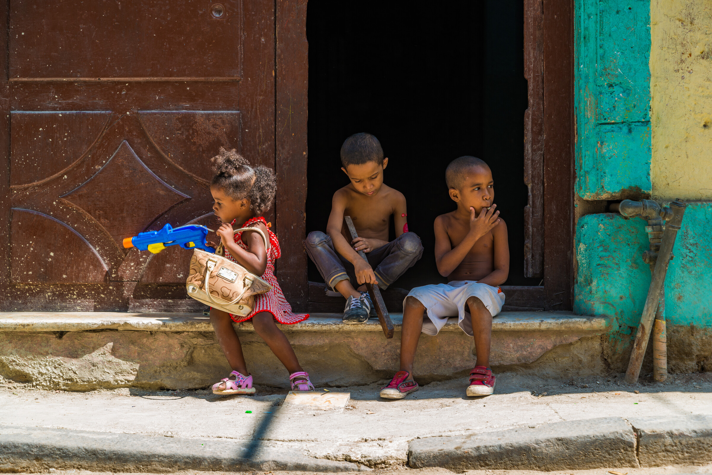 Children at a Havana window, a candid street moment caught with zone focusing
